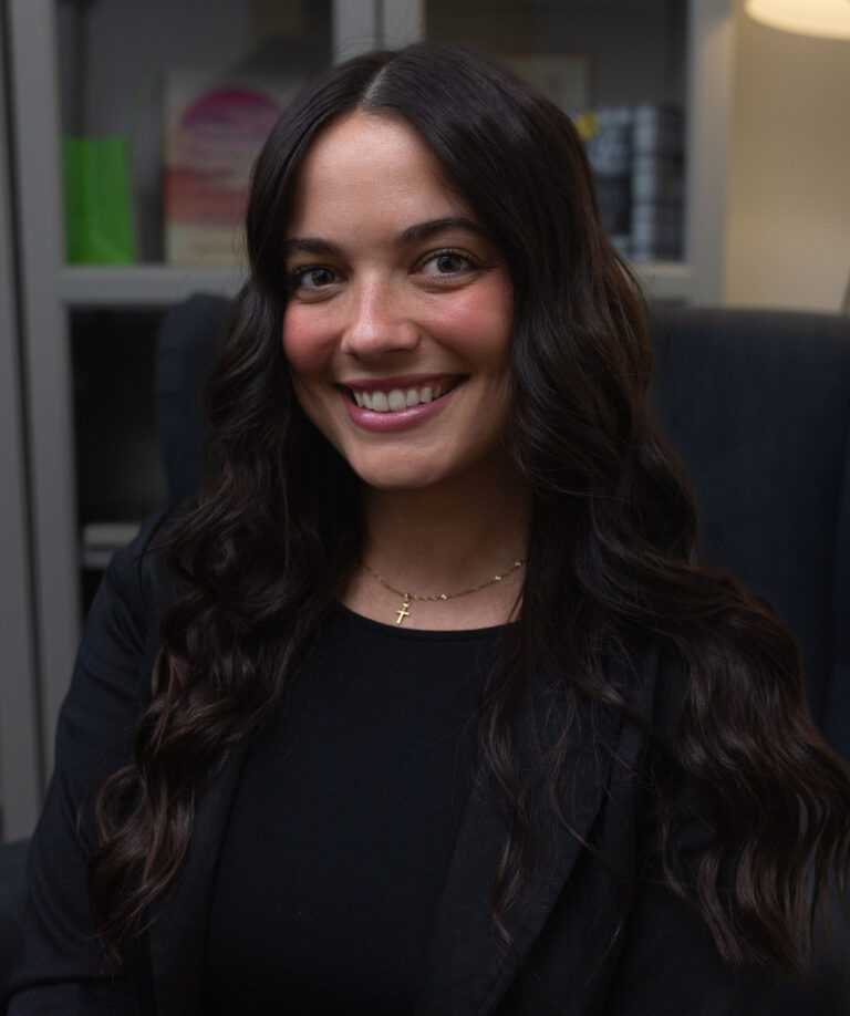 Hannah smiling at the camera in a black top