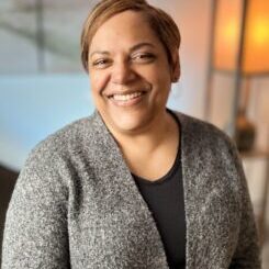 Lisa-Intro-480x587 Lisa smiling broadly with a grey sweater over a black top